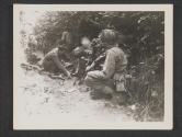 [The crew of a mortar keep up a steady fire at enemy positions from their place of concealment behind a hedgerow, somewhere in France. St Ouen des Besaces, France.]