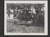 [Cpl Raymond Wojcik, Trenton, N.J., helps a German wounded officer near Chartres, France.]