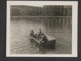 [A wounded U.S. infantryman rests in the bottom of the little boat in the above photo as fellow soldiers ferry him to an aid station across the Mozzelle River in France.]