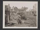 [When his platoon halted momentarily while moving through newly captured Bitburg, Germany, filling station was selected by PFC Carl Matters, of Columbus, O., for brief rest. Town was taken by 5th Infantry Division of 3rd U.S. Army.  5th Inf Div TUSA]