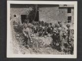 [Infantrymen gather around a well IN A French farmyard to fill their canteens before moving forward to the front lines.  St Ouen des Besaces, France.]