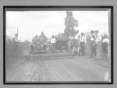 [auto racers parked with spectators in country road]