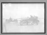 [two race autos on beach]