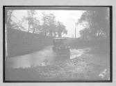 [auto driving through water on country road]