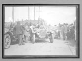 [auto surrounded by spectators in town "Mitchell"]