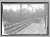 [auto crossing bridge "Welcome to Swanee County Florida"]