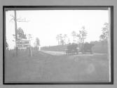 ["Welcome to Duval County" two autos driving on country road]