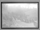 [auto tour lined up on country road]
