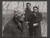 [Portrait of old man with couple standing in the background.]