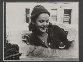 [Woman smiling while washing window.]