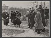 [Group standing by gravesite on the set of the film "Native Lands."]