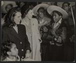 [Mexican band playing to two American girls in long coats]