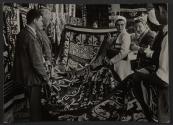 [American tourists looking at rugs and tapestries in Mexico]