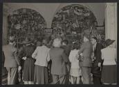 [Group of tourists crowded in front of Diego Rivera's mural, "The History of Mexico: Tierra y Libertad," in Mexico City]