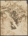 [Man standing among snow covered trees]