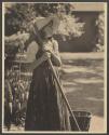 [Girl holding spading fork in garden]