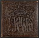 [Two men in fur hats standing in front of straw hut playing animal bagpipes] \ [Woman seated with large headress]