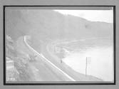 [auto driving along river and railroad tracks]
