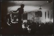 [Man standing on table during party at GAA Firehouse]

