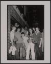 [Young men and one woman gathered outside of the Stonewall Inn the night that the riots began]
