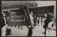 [Men holding flag that reads Gay Activists Alliance on street outside of Board of Education]
