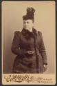 [Woman wearing hat and coat]