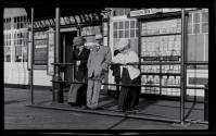[Group in front of studio window photo display]