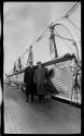 [Two men by lifeboat on deck of Lusitania]