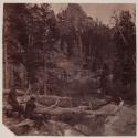 [Two men sitting near river]