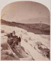 [Figure standing on hot springs terraces]