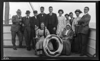 [Group on deck of ship, posed with a life-preserver]