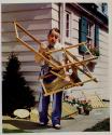 [Man struggling with folding lawn chair]