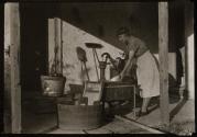 [Woman at water pump doing laundry]