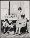[Woman & children in kitchen]