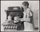 [Woman cooking at stove]