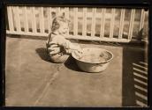[Child on porch with basin]