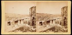 [Man standing next to bridge]
