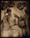[Woman smoking, baubles suspended from ceiling]