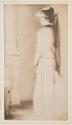 [Olga De Meyer, standing profile, hat and long veil]