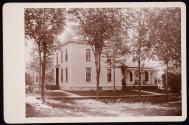 [House with porch and tree lined sidewalk]