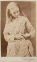 [Young girl fastening dress]