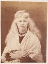 [Woman with shawl posing, her hands crossed on her lap]