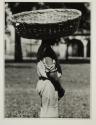 [Man with large basket on head]
