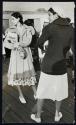 [Two women in white shoes]