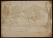 [Street view with three and one-half story brick structure, iron fence]
