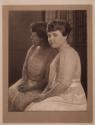 [Seated woman in front of mirror]