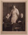 [Standing woman and two seated boys]