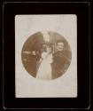 [Woman with arm around little girl, profile of a dog at left]