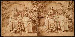 [Native American women and children posed in front of ivy covered wall]