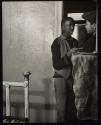 [Two boys in doorway of bedroom]